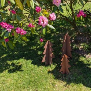 3 smukke træer ved dukkevogn 3 smukke træer i 3 forskellige størrelser ved en busk i haven.