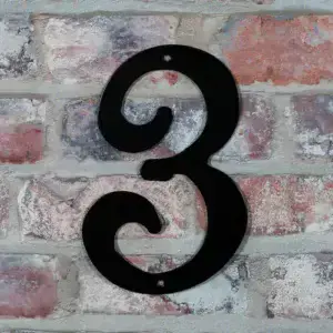 Husnummer i sort- nr 3 på husmur.
