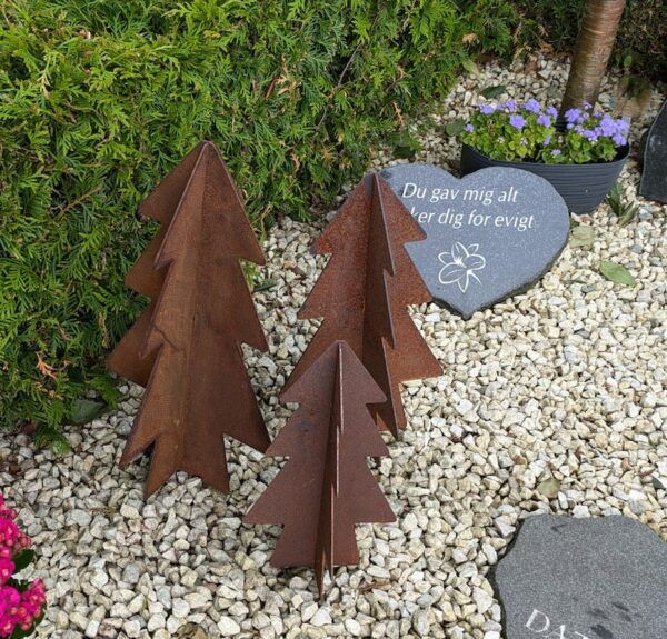 3 smukke træer i cortenstål på en kirkegård