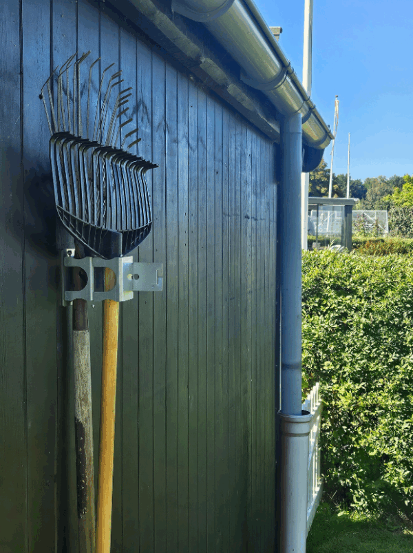Viting-redskabsophæng-2-3 Et redskabsophæng i metal på en sort trævæg der holder 2 redskab i med hovedet opad. Ophænget har individuelle holdere til hvert redskab. Lukket