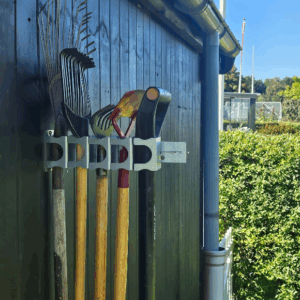 Et redskabsophæng til 5 redskaber. Hænger på en sort trævæg der holder 5 redskaber opad. Ophænget har individuelle holdere til hvert redskab.