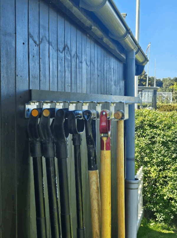 Viting-redskabsophæng-7-1 Et redskabsophæng i metal på en sort trævæg der holder 7 redskaber i deres greb. Ophænget har individuelle holdere til hvert redskab. Her har alle D greb.